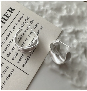 Detailed view of irregular matte S925 silver stud earrings with minimalist twisted design