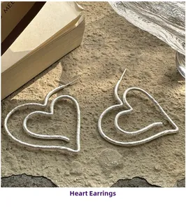 Detail view of heart earrings with vintage matte texture and layered double heart design