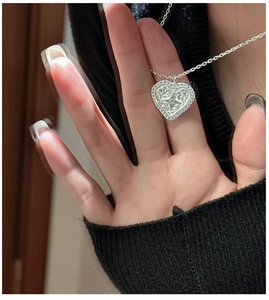 Detail of silver S925 heart pendant with micro-paved zircons and star engraving