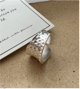 Dettaglio macro dell'anello in argento S925 opaco con trama martellata e zirconi incastonati