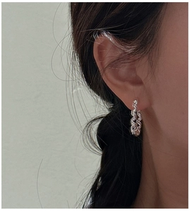 Detailed view of S925 sterling silver twisted rope hoop earring worn by a model