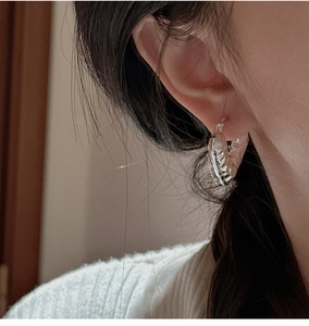 Dettaglio macro di orecchini a cerchio in argento sterling S925 con texture martellata