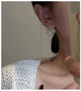 Detail view of S925 sterling silver grape cluster earrings worn by a model