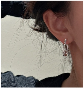 Detail view of twisted rope silver hoop earrings with vintage minimalist texture