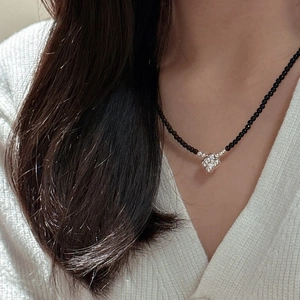 Minimalist S925 silver beaded necklace with silver flower pendant on a model in close-up