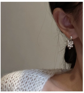 Close-up of S925 sterling silver grape cluster earrings worn by a model in soft light