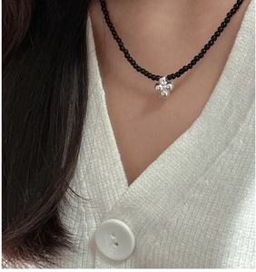 Detail of S925 silver beaded necklace featuring a black onyx chain and star pendant