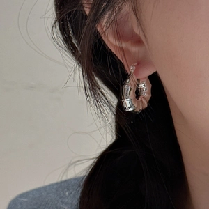 Créoles modernes en argent S925 motif bambou portées à l'oreille avec finition polie