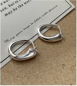 Gros plan de créoles en forme de U en argent sterling S925 avec une texture polie