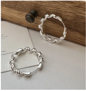 Detailed macro view of S925 sterling silver hoop earrings with twisted rope texture