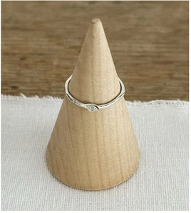 Detailed view of an irregular wavy S925 silver ring with a tiny gem on a wooden stand