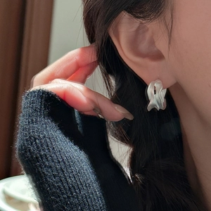 Irregular matte S925 sterling silver hoop earrings with textured finish on female model