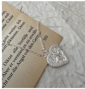 Detailed macro shot of vintage silver heart pendant with star zircon and hammered texture