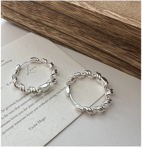Detailed close-up of S925 sterling silver wave hoop earrings with twisted rope design