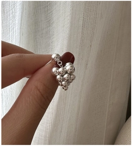 Detailed close-up of S925 sterling silver grape-shaped earrings held by hand