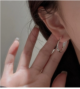Gros plan de boucles d'oreilles créoles épaisses en U en argent sterling S925 sur modèle