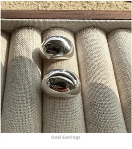 Close-up of polished silver S925 sterling silver oval stud earrings on display tray
