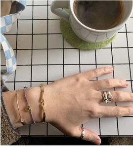 Detail showing S925 sterling silver square ring paired with stylish bracelets and jewelry