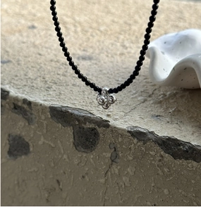 Detail view of S925 silver beaded necklace featuring a glossy black onyx stone band