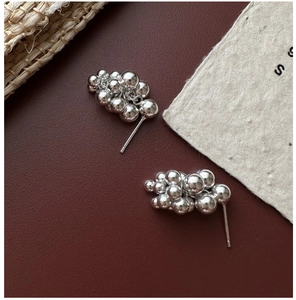 Macro shot of S925 sterling silver grape cluster stud earrings on premium leather
