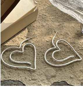 Detail view of heart-shaped S925 silver earrings with retro matte hammered texture