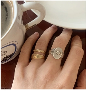 Gros plan d'un ensemble de bagues rétro en argent S925 avec anneau doré et chevalière vintage