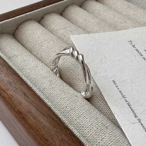 Minimalist S925 sterling silver knotted ring with twisted rope design on beige velvet