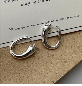 Vue macro de boucles d'oreilles créoles en U en argent sterling S925 au fini poli