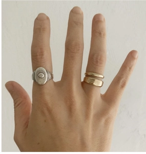 Détail d'une bague chevalière rétro en argent S925 et d'une bague double dorée ajustable