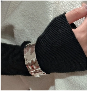 Macro shot of liquid metal style wide cuff bracelet with irregular hammered texture
