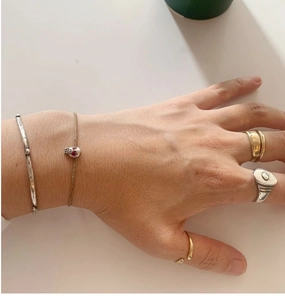 Gros plan de bijoux superposés avec bague en argent et bracelet crâne sur une main
