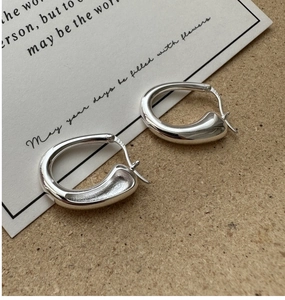 Détail du poinçon S925 sur des boucles d'oreilles géométriques en argent sterling