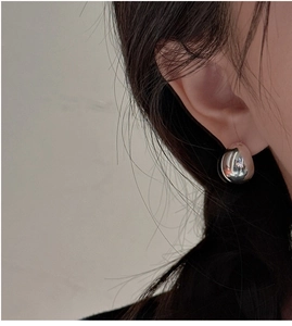 Close-up of polished S925 sterling silver drop stud earring on female model