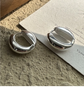 Close-up of chunky silver S925 sterling silver hoop earrings with a polished mirror finish