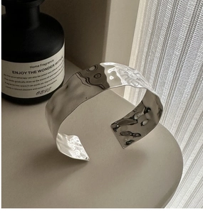 Close-up of a wide S925 silver cuff bracelet with irregular hammered water ripple texture