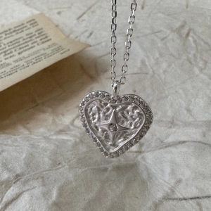 Vintage S925 silver heart necklace with zircon star pendant on a textured paper background