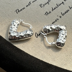 Orecchini a cerchio in argento sterling S925 con texture martellata su sfondo lino