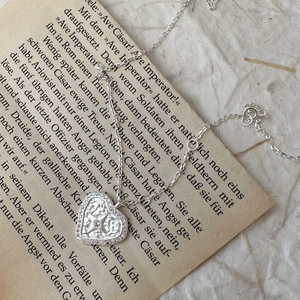 Vintage S925 sterling silver heart necklace with star relief and zircon on old book
