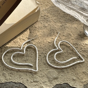S925 sterling silver hollow double heart earrings with matte finish on stone surface