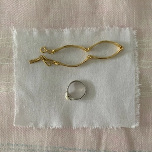 S925 sterling silver square ring and gold wavy chain bracelet set on linen fabric