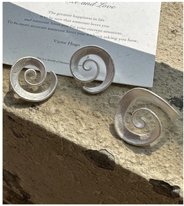 Macro detail of the spiral Mobius loop earring with a matte sandblasted silver texture