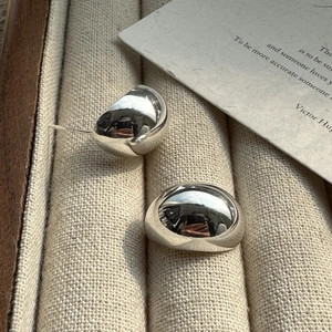 S925 sterling silver minimalist glossy dome stud earrings shown on a jewelry display