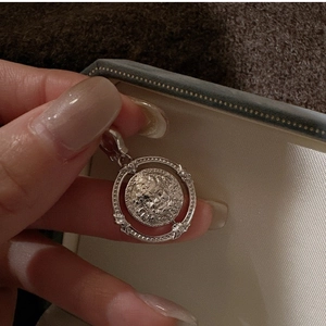 Gros plan d'un pendentif en argent S925 avec disque rotatif et portrait de style rétro