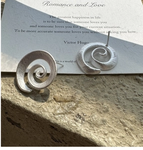 Detailed view of S925 sterling silver spiral earrings with brushed metal texture