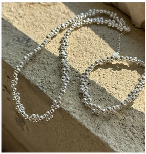 Detail of S925 sterling silver beaded bracelet with lobster clasp and hallmark on stone surface