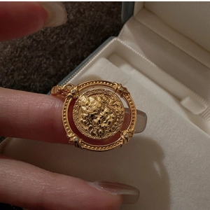 Détail d'un pendentif pièce d'or vintage avec relief et motifs de clé grecque sur le bord