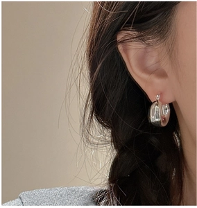 Polished silver hollow hoop earring shown on ear for a minimalist jewelry aesthetic