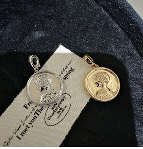 Detailed close-up of S925 sterling silver coin pendants with relief portrait and zircon