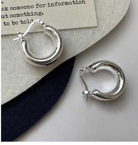 Close-up of S925 sterling silver hollow hoop earrings showing metal hallmark and texture