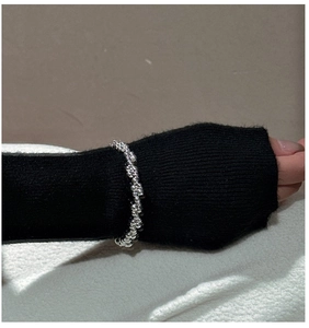 Detail of S925 sterling silver beaded bracelet styled over a black knit sleeve